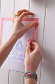 Woman sticking picture of Paris with decorative masking tape
