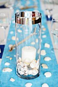 Maritime table decoration: shells in candle lantern