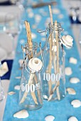 Maritime table decoration: twigs in glass bottles