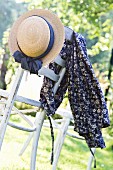 Romantic dress and straw hat on garden chair