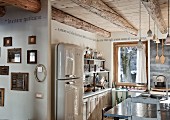 Open-plan kitchen area in wooden chalet with retro fridge & island counter