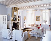Weisses Wohnzimmer im französischen Landhausstil mit Kamin & Holzdecke