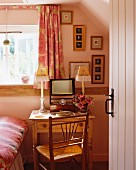 Blick durch offene Tür in rosafarbenes Schlafzimmer mit Frisiertisch aus Kiefer