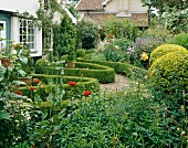 Englischer Bauerngarten mit Kiesweg und niedrigen Buchsbaumhecken in Formschnitt