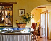 Blick von Landhausküche mit Spüle durch Rundbogen in Esszimmer
