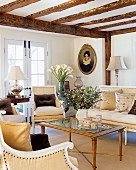Elegante Salonmöbel im Wohnzimmer mit rustikaler Holzbalkendecke