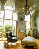 Wintergartensalon mit Rosenmalerei auf der gewölbten Decke; antiker Polstersessel, Ottomane mit Rosenmuster und vergoldete Ferkelfigur in Raummitte
