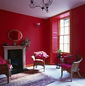 Rotgetöntes Wohnzimmer mit Korbstühlen um offenem Kamin in traditionellem Ambiente