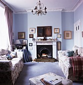 Blau getöntes Wohnzimmer mit zwei gemütlichen Polstersofa vor offenem Kamin in traditionellem Ambiente