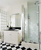 Badezimmer in schwarz-weiss mit Waschtisch, Duschkabine, Wand aus Glasbausteinen & Fliesenboden