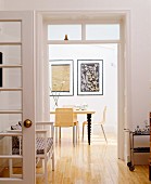 Blick in Esszimmer mit Wandbildern, stühlen & Esstisch mit gedrechselten Tischbeinen