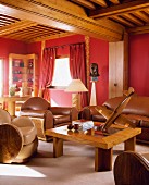 Wohnzimmer mit roten Wänden & Sofagarnitur aus Holz und Leder
