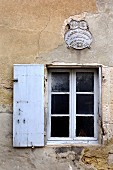 Old window in weathered house facade (Eric Linard art gallery, France)