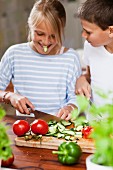 A girl and a boy cutting vegetables
