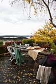 Autumnal terrace with rustic dining table and view across Norwegian skerry coast