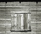 Geschlossener Holzfensterladen eines rustikalen Holzhauses