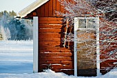 Swedish wooden cabin surrounded by snowy ground