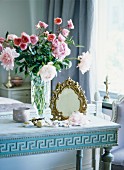 Antique mirror and flower vase on table