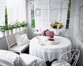 White round table, bench & chairs on veranda