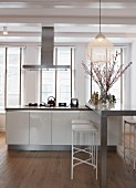 Modern kitchen island with breakfast bar in front of large windows