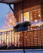 Balcony decorated for Christmas with white Christmas tree & fairy lights