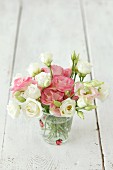 Romantic bouquet of flowers with roses and lisianthus in a glass of water