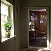 View through open interior door into dignified interior with solid wooden panelling