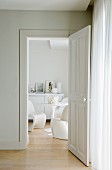 Blick in eleganten weißen Wohnbereich mit Sideboard und Sitzgruppe