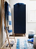 Blue hall cupboard and wooden coat rack