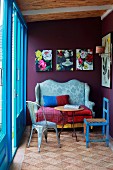 Sitzecke mit antikem Sofa, Beistelltisch & Stühlen vor blauen Terrassentüren