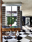 Improvisierte Kochinsel aus alter Werkbank mit Gasherd in offenem Wohnraum mit eleganten Schachbrettfliesen