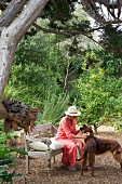 Woman brushing dogs in luxuriant garden