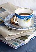 Vintage teacup and biscuits on plate on newspaper