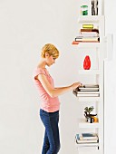 Young woman standing in front of bookcase