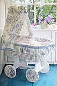 Romantic cot made from old bassinet with hand-crafted canopy in white and blue toile de jouy fabric