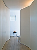 Minimalist hallway with stool and indirect lighting