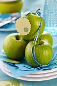 Green apples with satin ribbon and tag on stacked plates