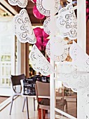 Curtain of doilies on strings in front of dining area