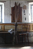 Vintage skis next to Thonet chair in sparsely-furnished farmhouse parlour