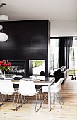 Charcoal-grey partition between living room and dining room with Eames chairs