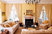 Upholstered set with coffee table and fireplace in the living room with French windows and yellow walls