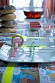 Place setting with rubber band stretched over plate and roll of washi tape as name tag on tablecloth made from comic pages