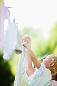 Caucasian mother and baby hanging laundry on clothes line