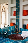 Blau gefliester Waschtisch mit eingebauter Metallschüssel und Vintage Armatur in Badezimmerecke