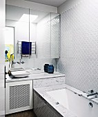 Spiegelschrank über Waschbecken neben Badewanne