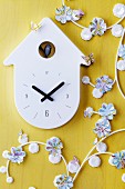 Garland of flower shapes punched out of maps next to wall clock
