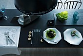 Purist place settings in charcoal and white with handwritten menu on dark pendant lampshade
