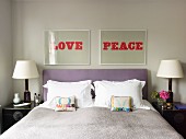 Pictures with words LOVE and PEACE above double bed with lilac headboard and small scatter cushions