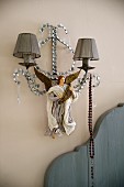 Sconce lamp with small fabric lampshades and painted angel figurine