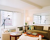 Klassisches Wohnzimmer mit Polstermöbeln und ovalem Tisch; Vergrösserungseffekt durch Wandspiegel